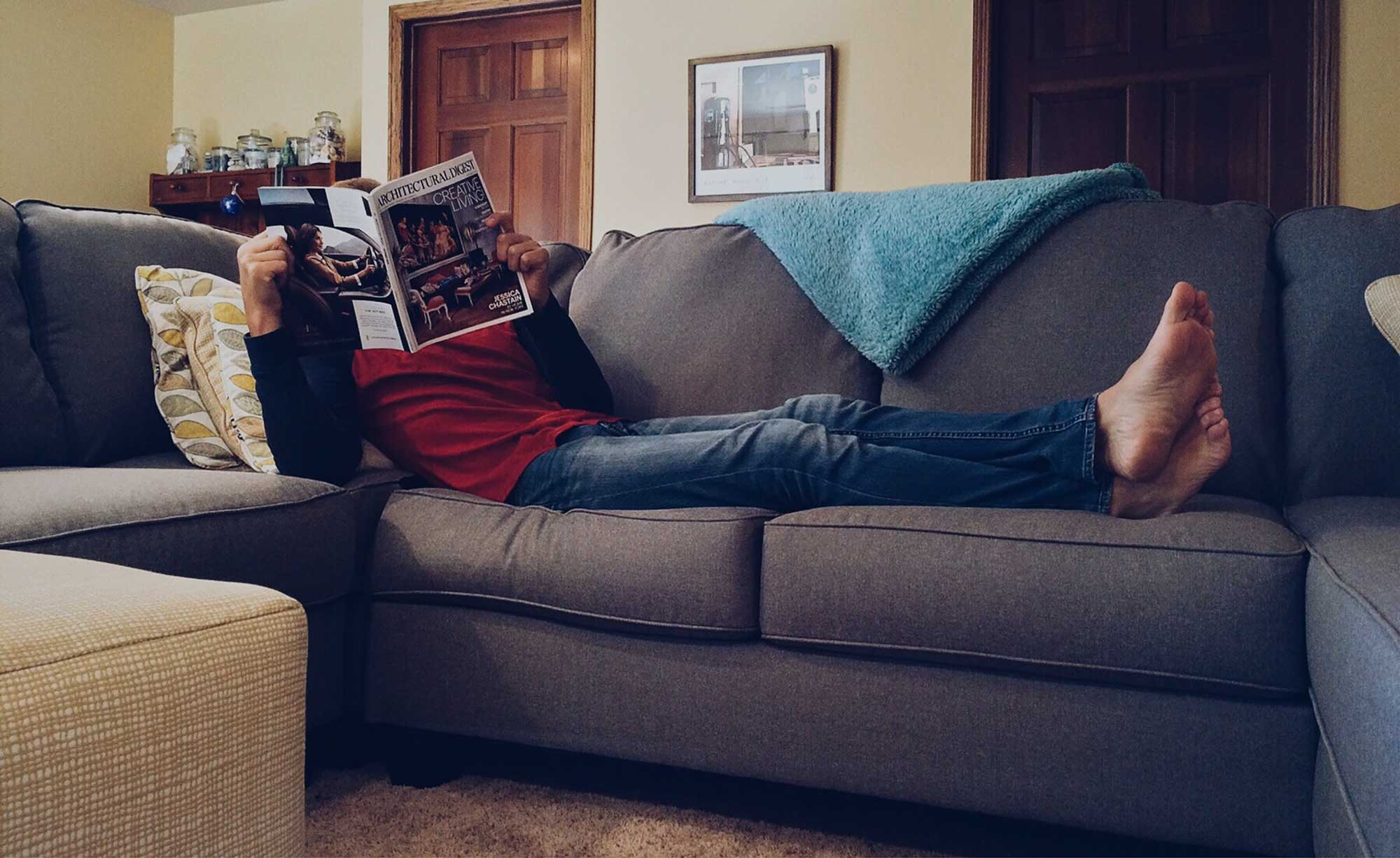 Person on couch looking at a magazine